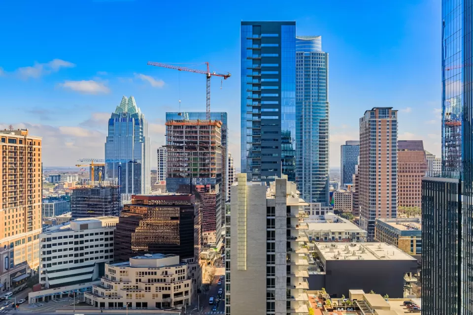 Downtown Austin, Texas skyline with cranes on a sunny day.